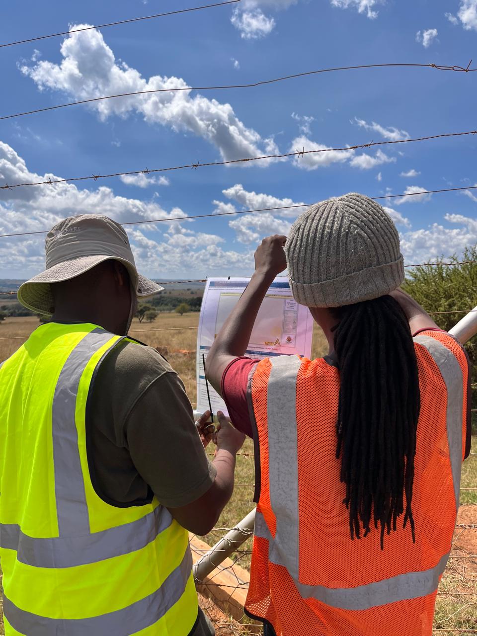 Team members reviewing documents at a gate